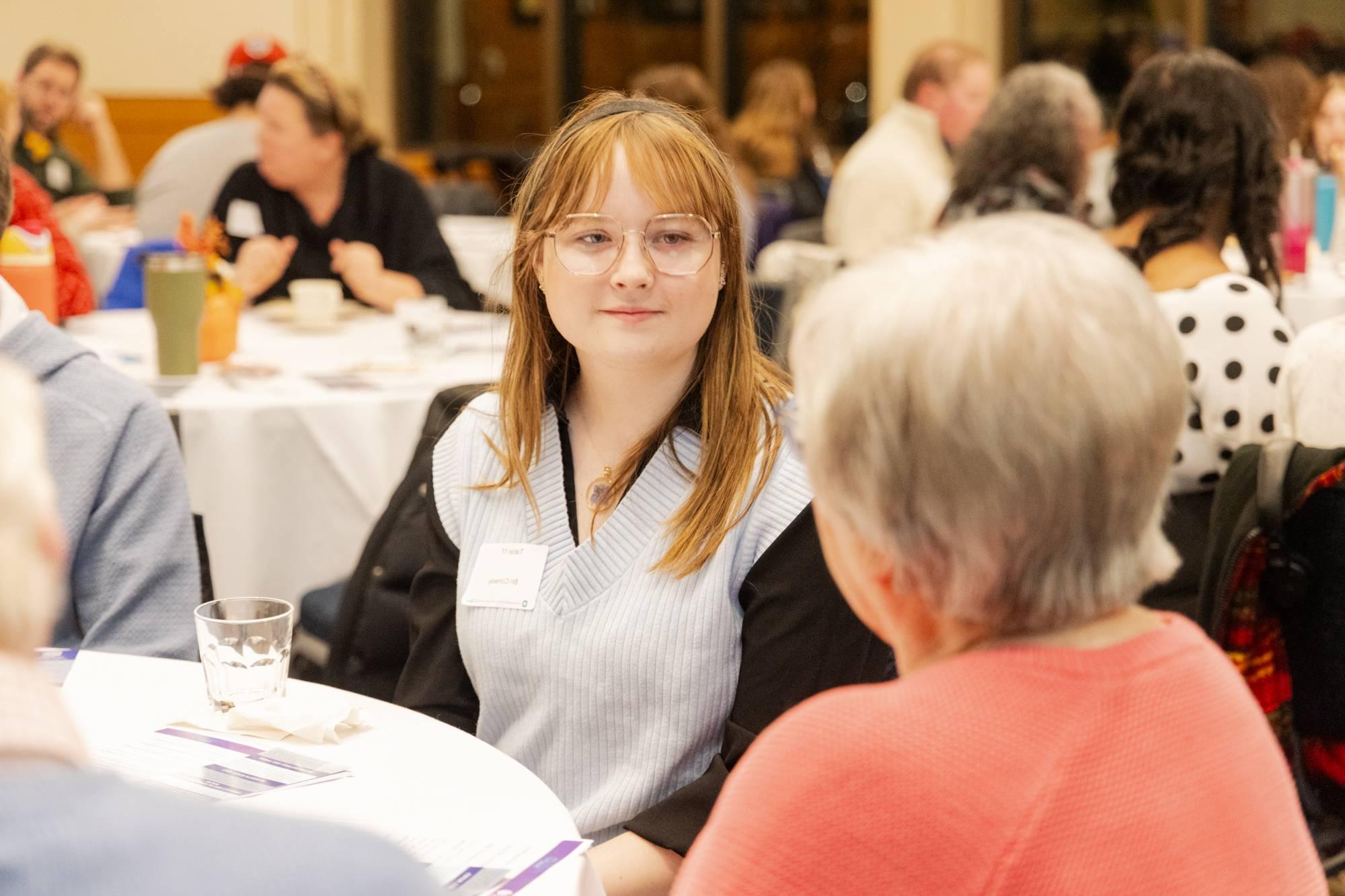 Gen Z attendee listens closely to an older attendee